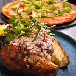 Filled jacket potato with salad and pizzas