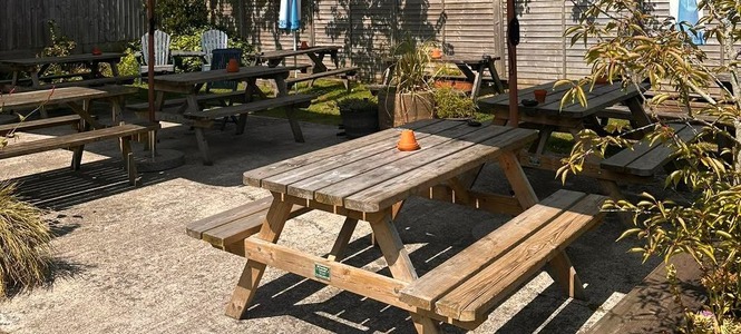 Sunny beer garden with picnic tables and parasols